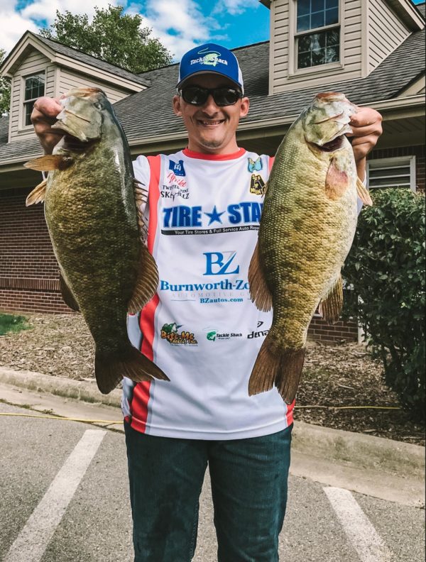 Mike Raber holding up two bass