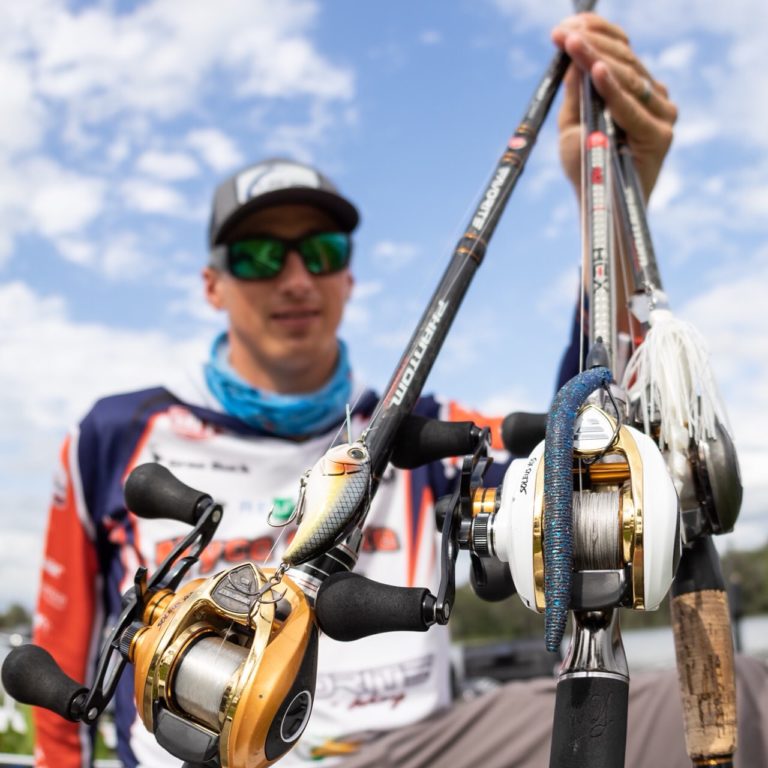 grae buck holding 2 fishing rods rigged with shad spawn lures