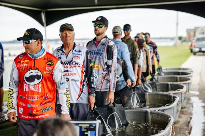Kyle Gelles and other bass fishing anglers standing in line at the water tanks at a tournament weigh in